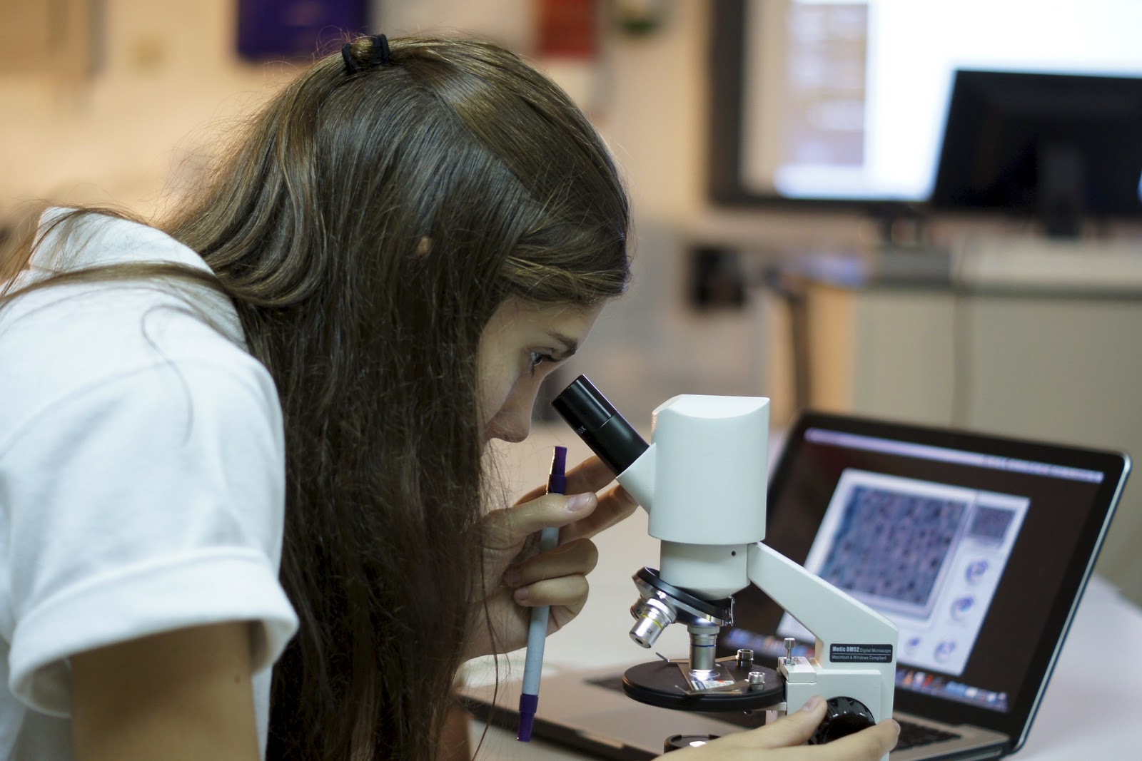 student using microscope